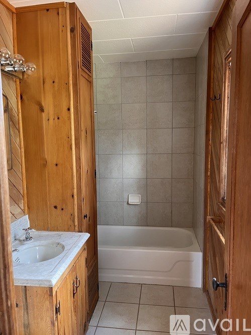 A bathroom with a white sink and a white bathtub.