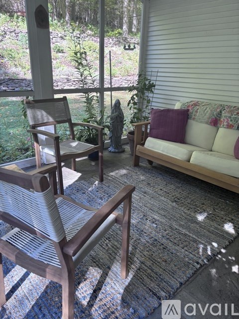 A patio with a couch, chair, and table.