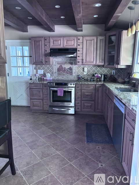 A kitchen with wooden cabinets and a tile floor.
