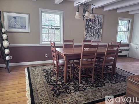 A dining room with a table and chairs.