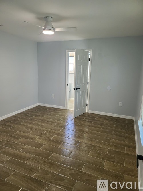 A room with a wooden floor and a door.