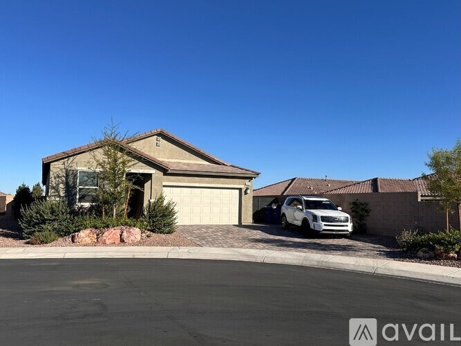 A house with a white car parked in front of it.