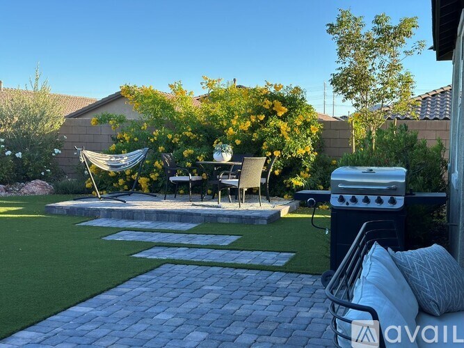 A backyard with a patio and a grill.