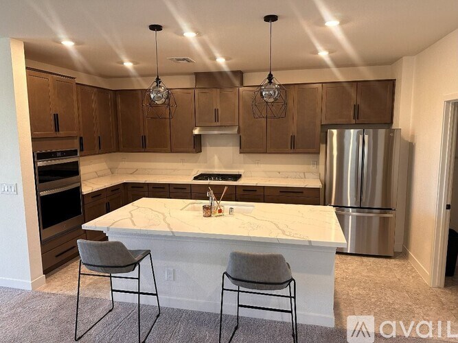 A kitchen with a marble island and modern appliances.