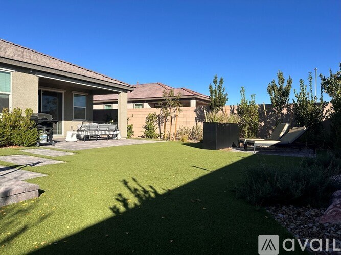 A house with a well-maintained lawn and a clear blue sky.