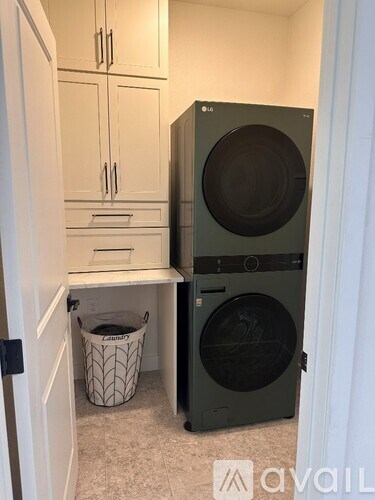 A black LG washing machine sits in a small laundry room.