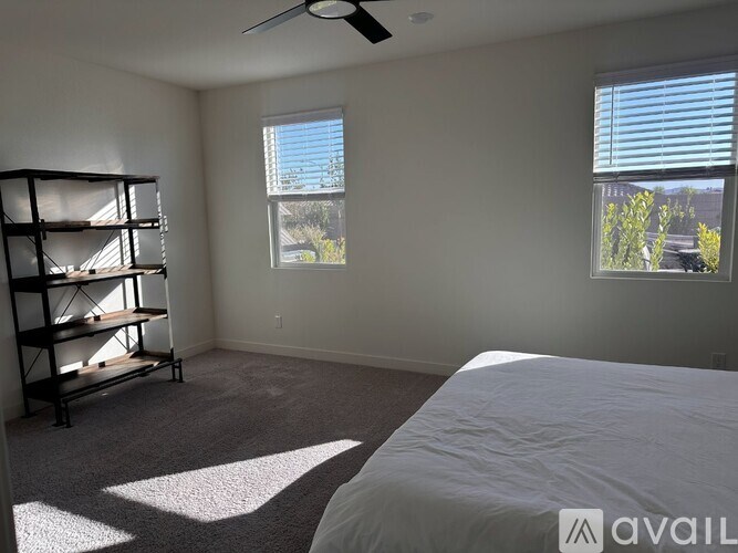 A bedroom with a large bed and a shelving unit.