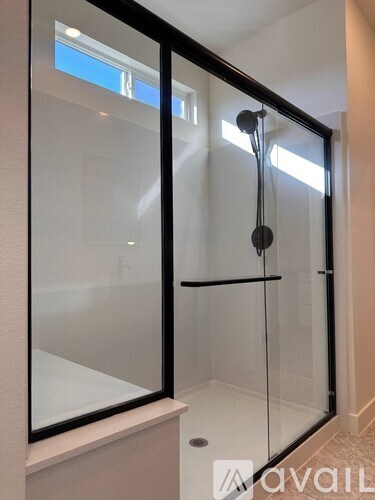 A glass shower door with a black frame and a glass door.