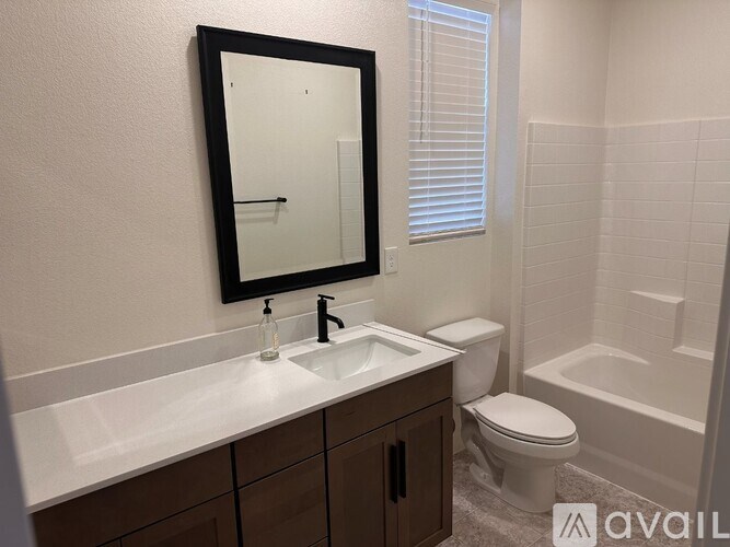 A bathroom with a sink, toilet, and tub.