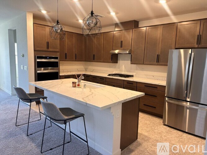 A kitchen with a marble countertop and stainless steel appliances.