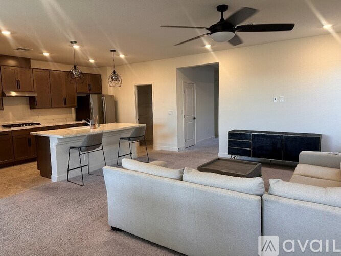 A living room with a couch, a television, and a kitchen area in the background.