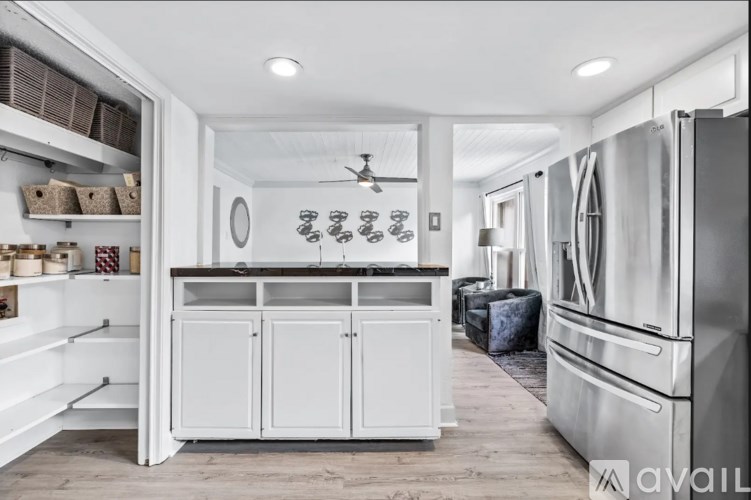 A kitchen with white cabinets and a refrigerator.