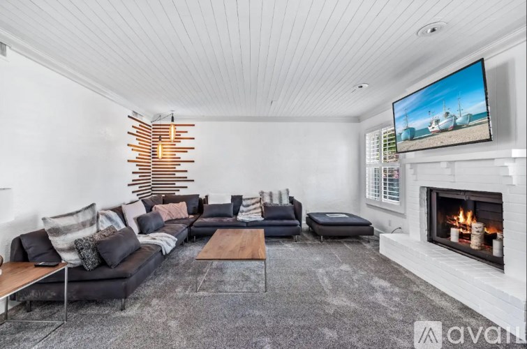 A modern living room with a fireplace and a television.
