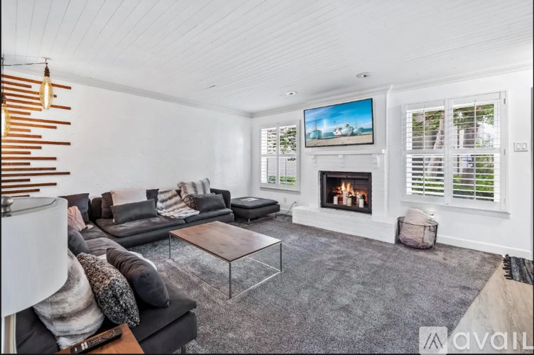A modern living room with a fireplace and a flat screen TV.