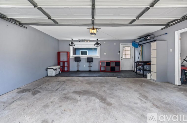 A large, empty garage with a concrete floor and white walls.