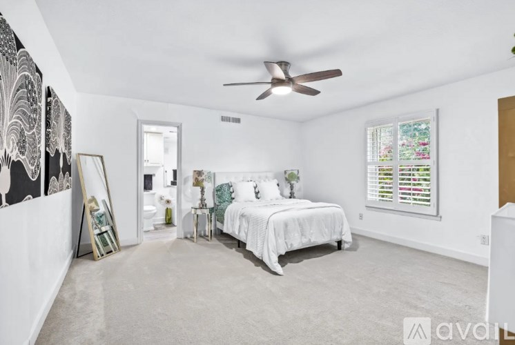 A bedroom with a large bed and a ceiling fan.