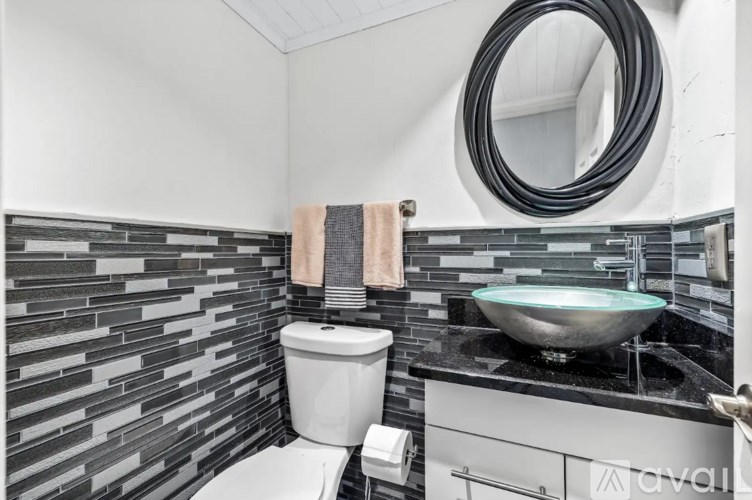 A bathroom with a toilet, sink, and mirror.