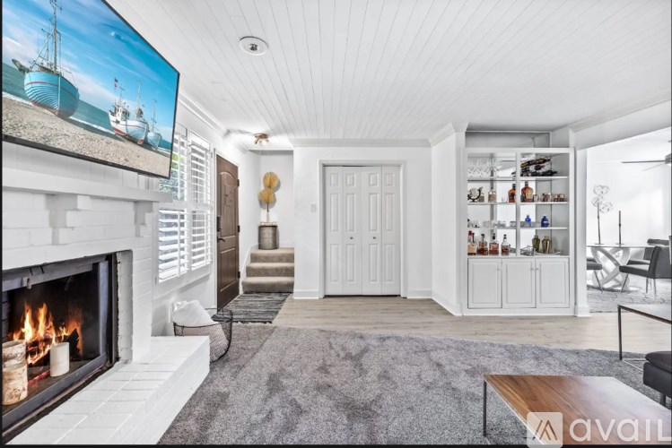 A modern living room with a fireplace and a television on the wall.
