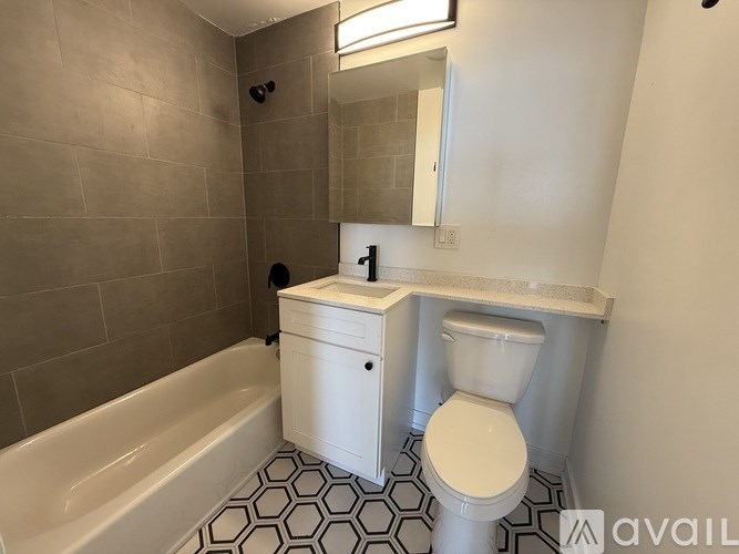 A bathroom with a toilet, sink, and bathtub.