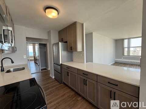 A kitchen with a black stove top oven and wooden cabinets.