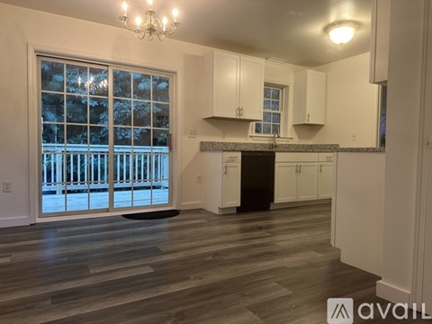 A kitchen with white cabinets and a black stove top oven.