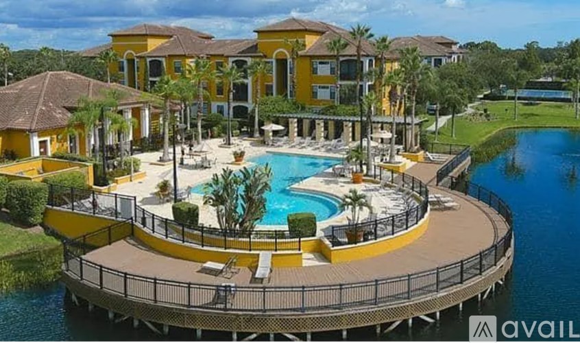 A large yellow building with a pool in front.