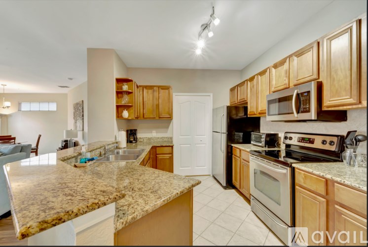 A kitchen with granite countertops and wooden cabinets.