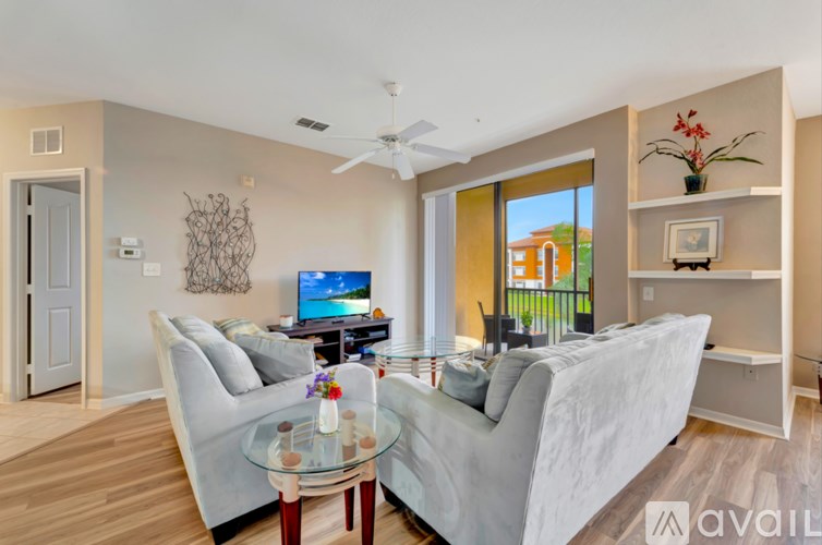 A living room with a glass table and two grey couches.