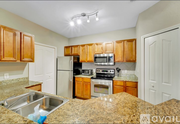 A kitchen with granite countertops and wooden cabinets.
