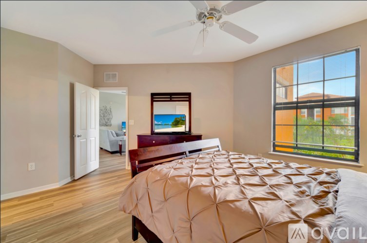 A bedroom with a large bed and a ceiling fan.