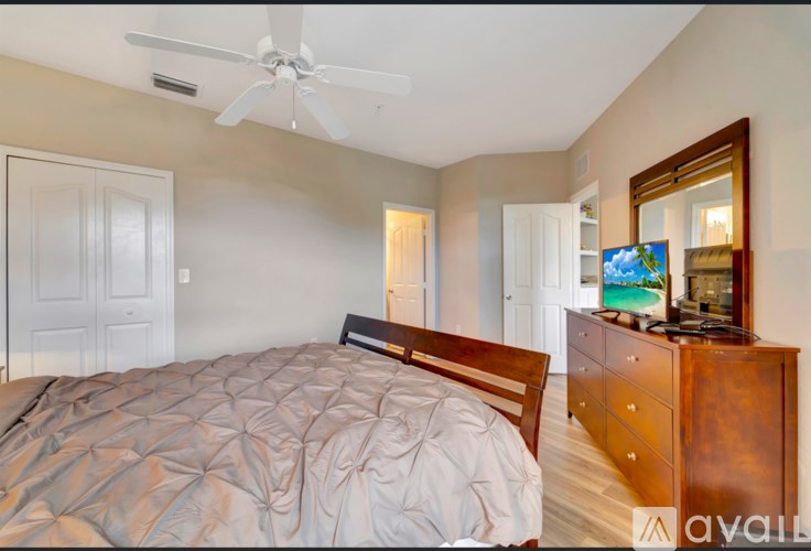 A bedroom with a bed, dresser, and mirror.