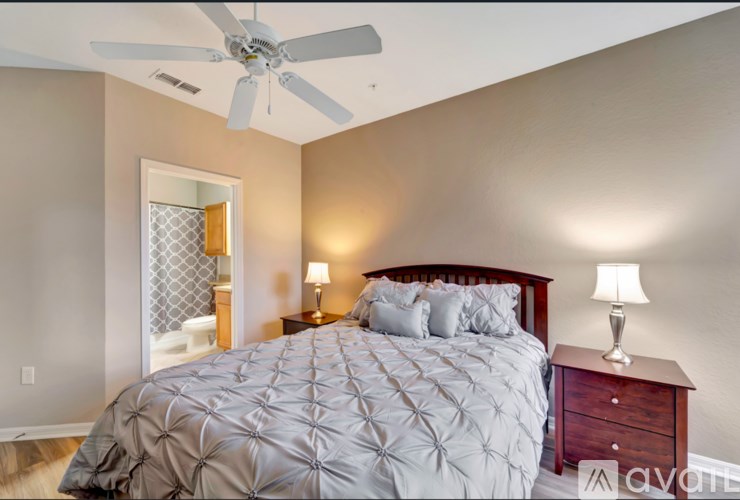 A bedroom with a large bed and a ceiling fan.
