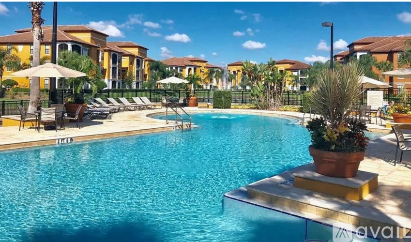 A large swimming pool surrounded by lounge chairs and umbrellas.