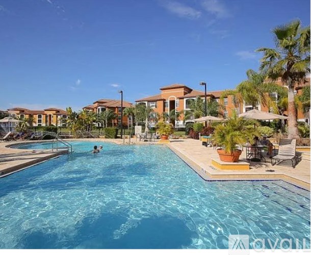 A swimming pool with a person in it and a building in the background.
