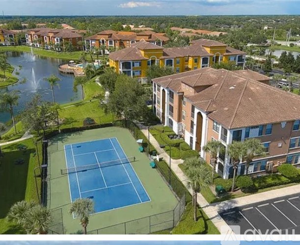 A tennis court is surrounded by apartment buildings.