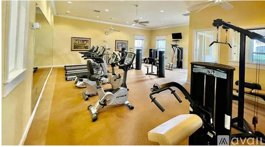 A gym with a variety of exercise equipment including treadmills, stationary bikes, and weight machines.