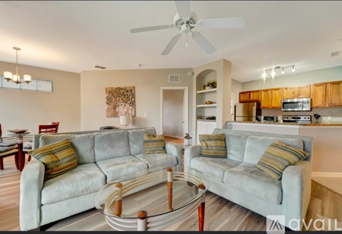 A living room with a grey couch and a glass coffee table.