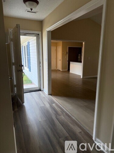 A room with a sliding glass door leading to a backyard.