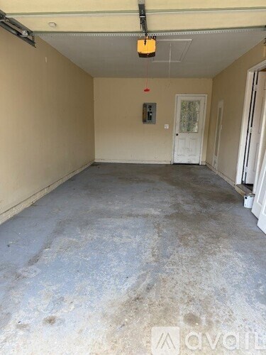 A room with a white door and a window with a yellow light.