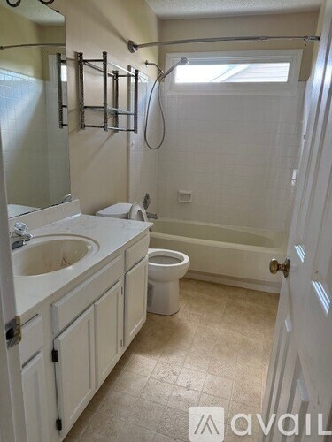 A bathroom with a toilet, sink, and shower.