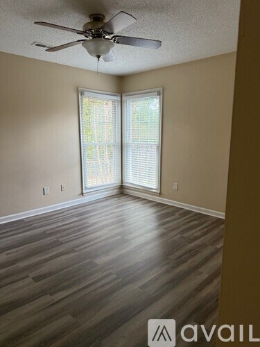 A room with a ceiling fan and sliding glass doors.