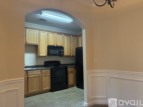 A kitchen with wooden cabinets and black appliances.