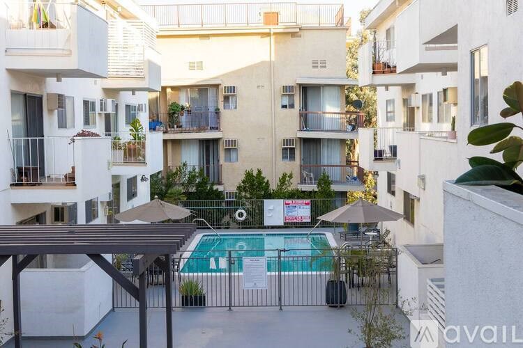 A pool surrounded by apartment buildings with a sign that says "available".