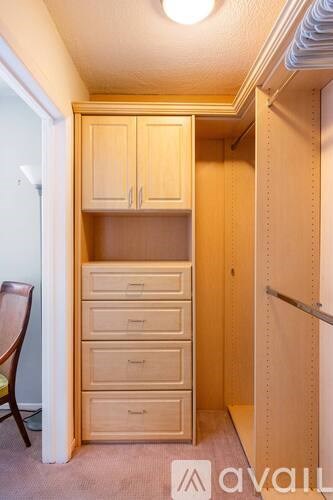 A small closet with a chair and drawers.