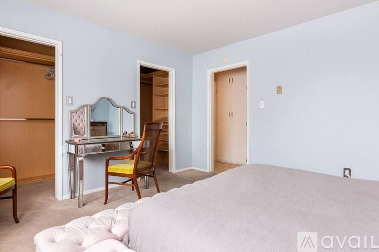 A bedroom with a bed, desk, and chair.