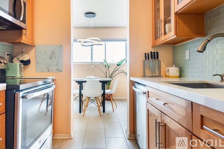 A kitchen with wooden cabinets and a table with chairs.