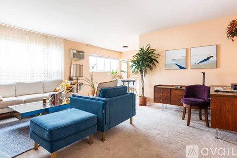 A living room with a blue chair and a white couch.