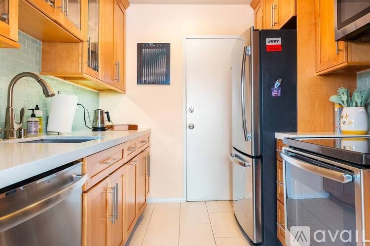 A kitchen with wooden cabinets and a black fridge.