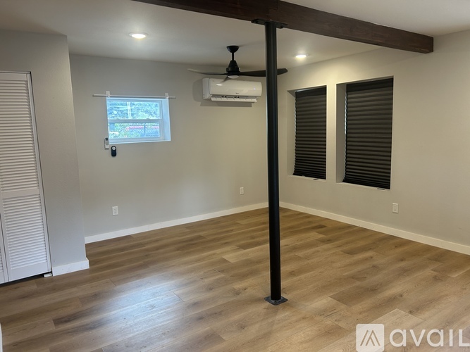 A dining room with a fireplace and a kitchen area in the background.