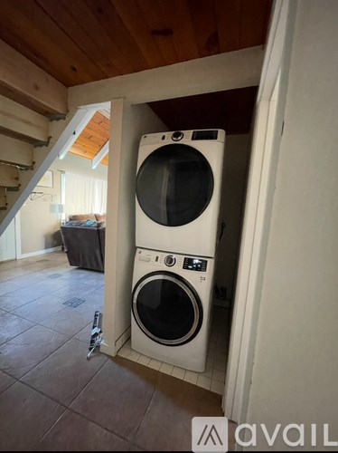 A washer and dryer are stacked on top of each other in a laundry room.